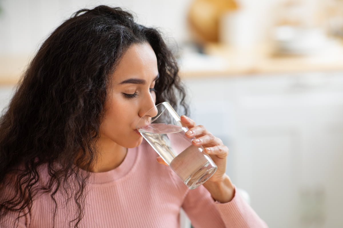 Woman with curly hair drinking water Woman with curly hair drinking water